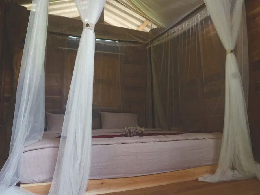 Bed with white net curtains